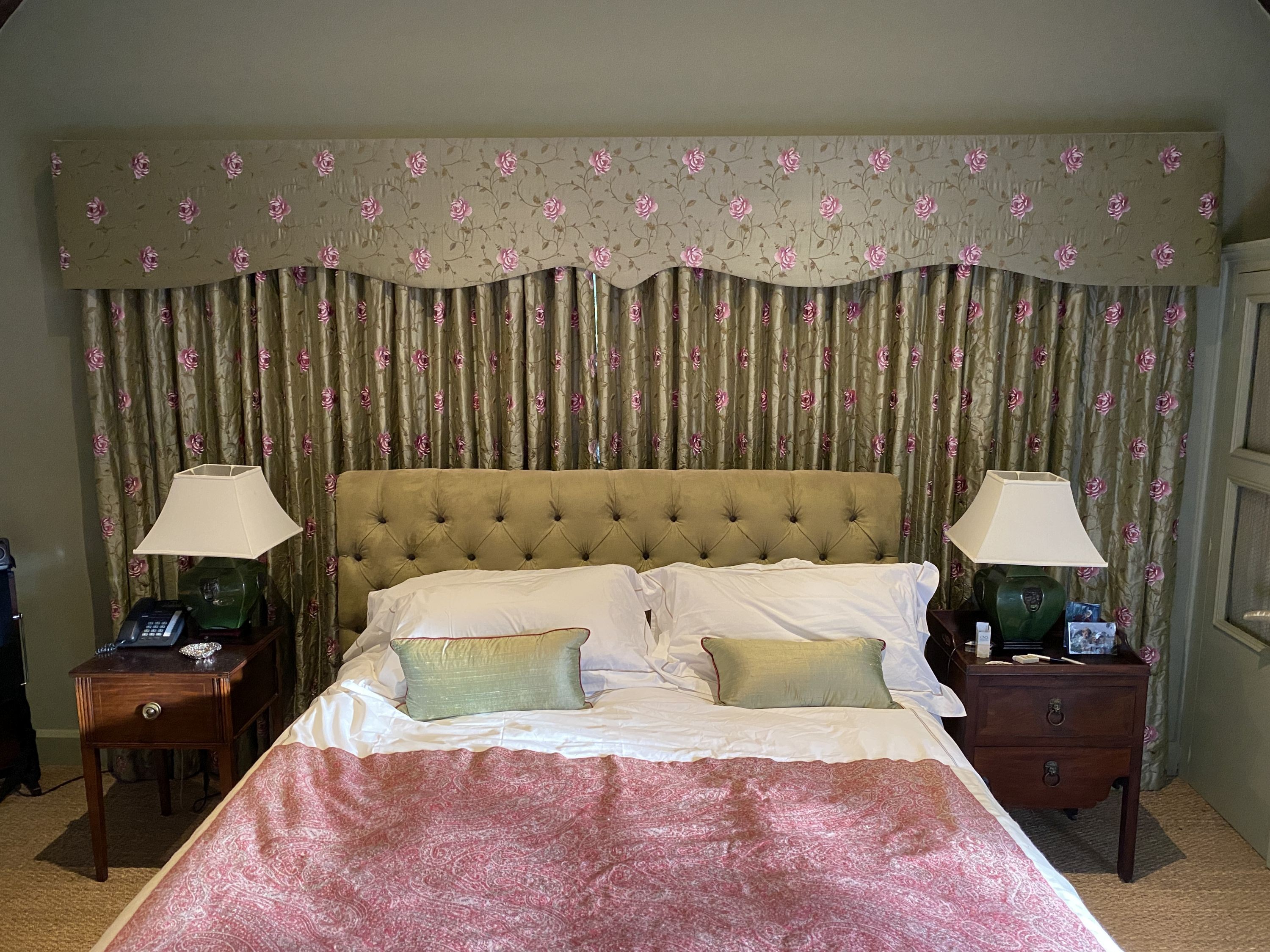 A pair of embroidered woven silk curtains, with pelmet, decorated with pink roses on a eau de nil ground, drop 2.3m, made to generously fit an aperture of 4m width